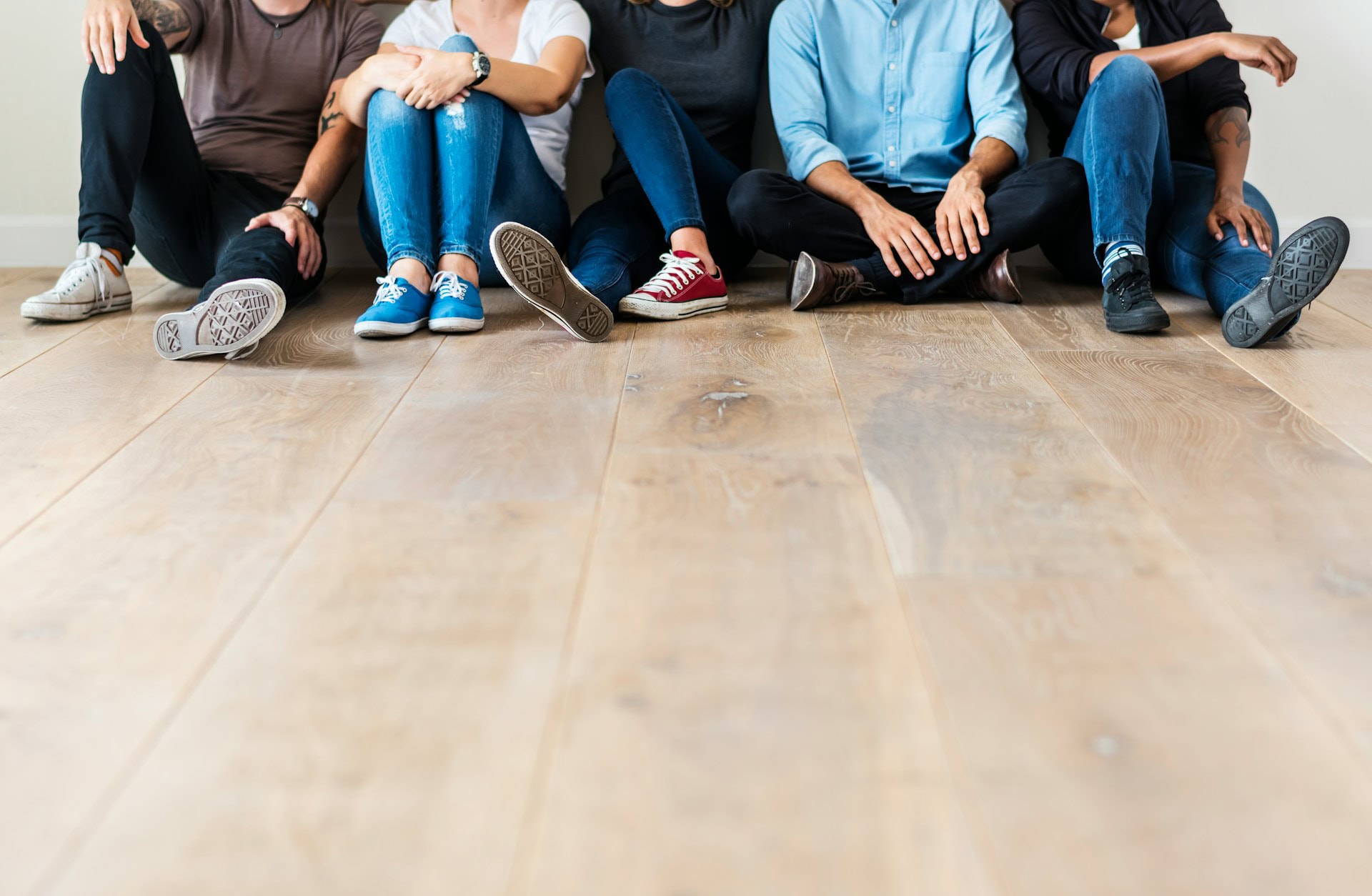 Group of diverse young adults sitting on the floor, engaging in mental health support.