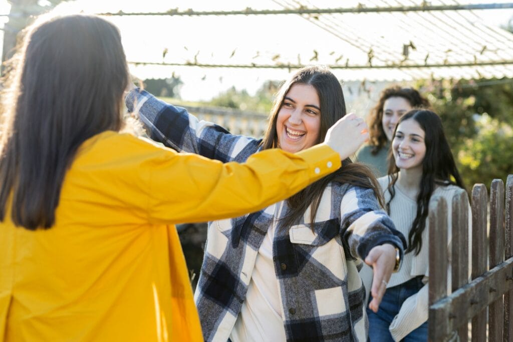 Supportive teen girls engaging in mental health awareness activity outdoors.