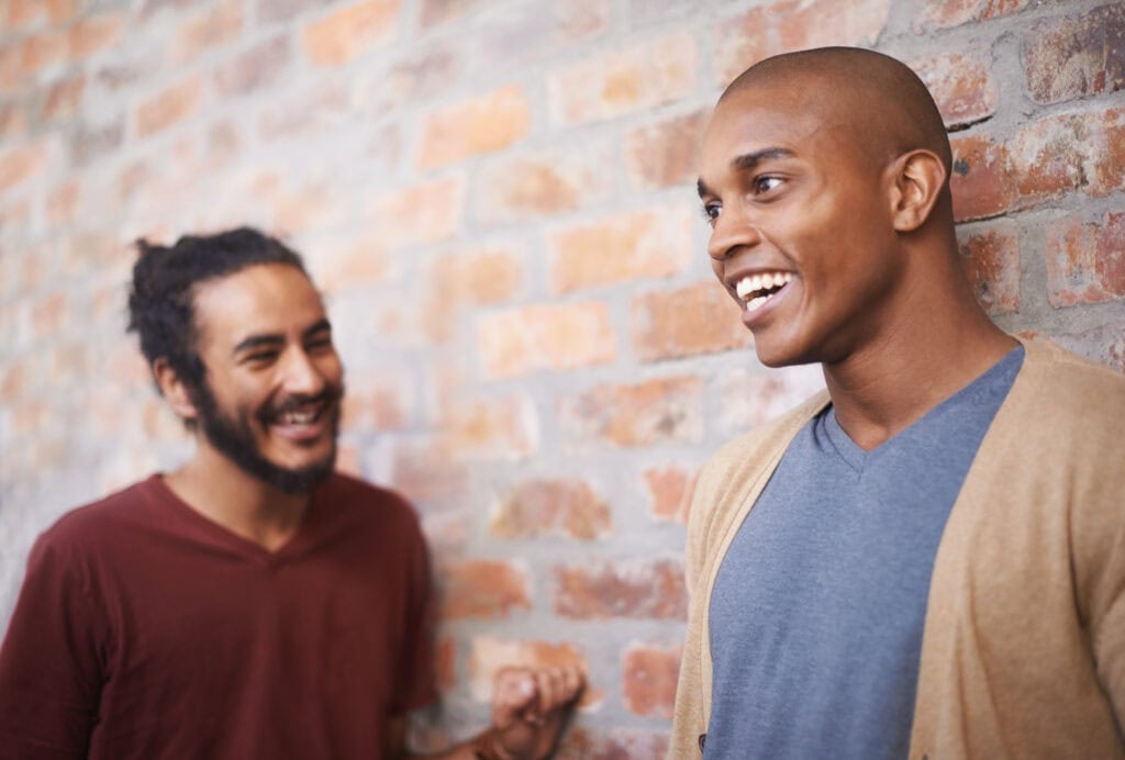Two men smiling and talking in a therapy session at Montgomery Behavioral Health.