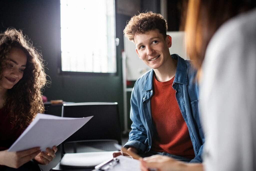 Young adults engaging in trauma-informed therapy in a supportive setting.